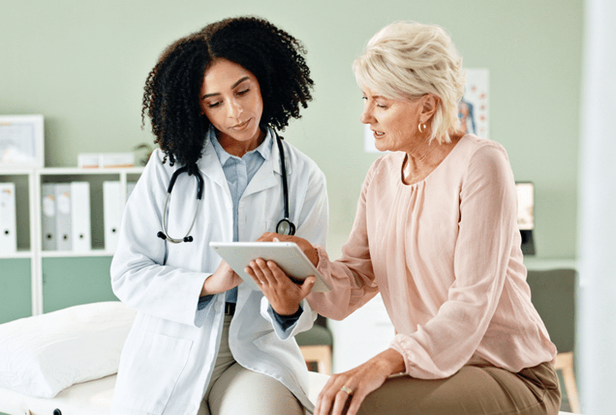 Doctor and patient reviewing information on tablet.